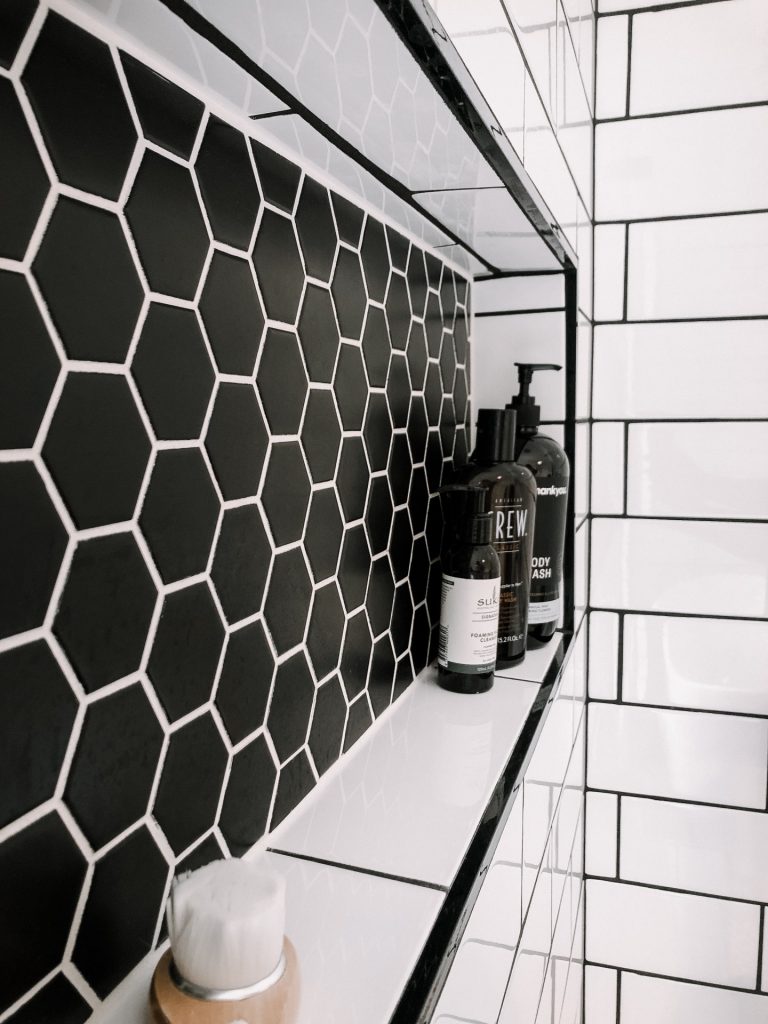 Black and white hexagonal tiles in a shower niche