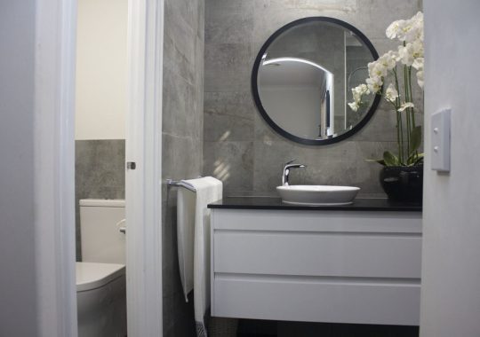 small bathroom renovation with round mirror modern