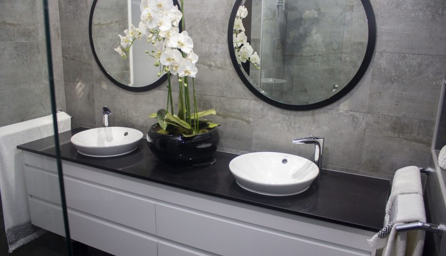 black and white designer bathroom with round mirrors