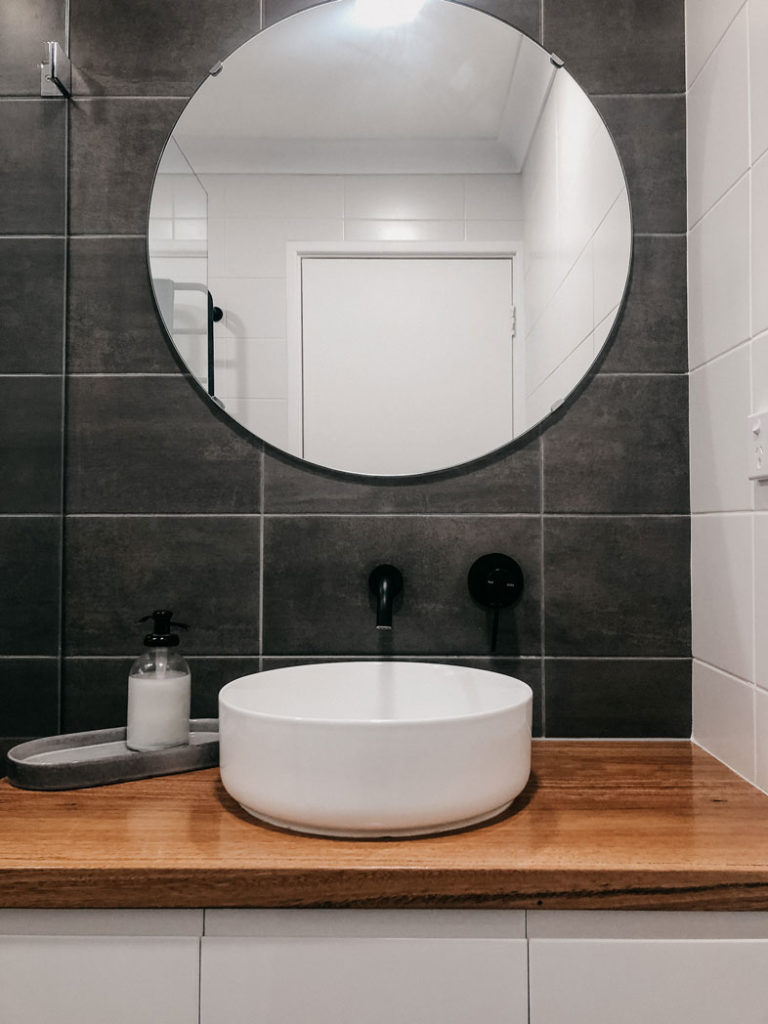Small bathroom renovation in Perth, round mirror and wood countertops