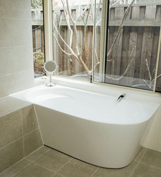large bath with window above it