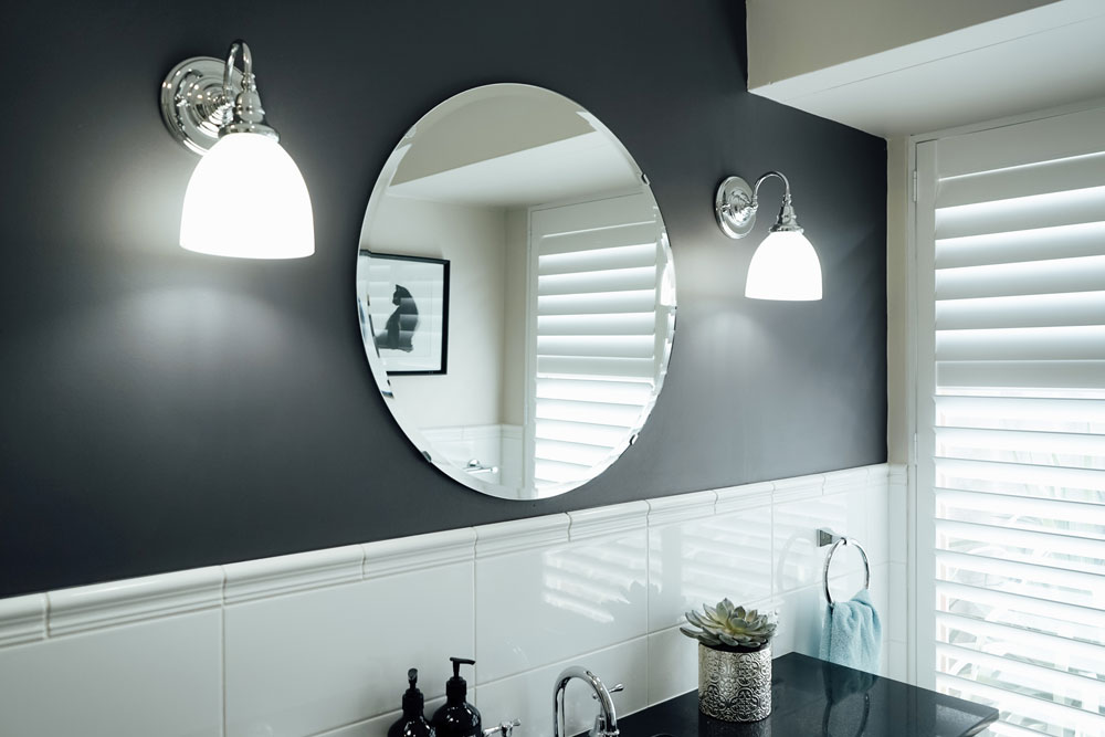 modern mirror on black wall with lamps