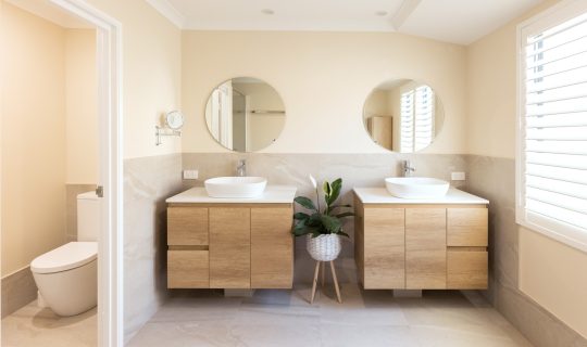 Two vanities and rounded mirrors side-by-side in renovated bathroom