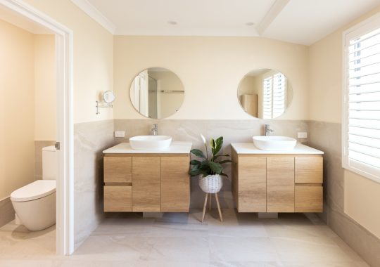Two vanities and rounded mirrors side-by-side in renovated bathroom
