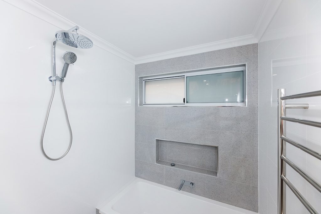 Large grey & white shower and shower head in bathroom