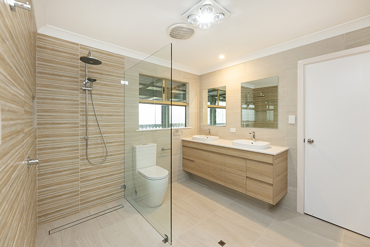 This new bathroom renovation has a spacious walk-in shower, a floating vanity with two sinks, and two mirrors