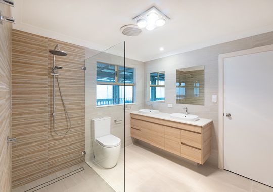 Narrow bathroom with twin vanities and large shower