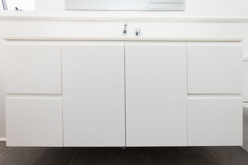 A floating vanity with handleless cupboards and drawers