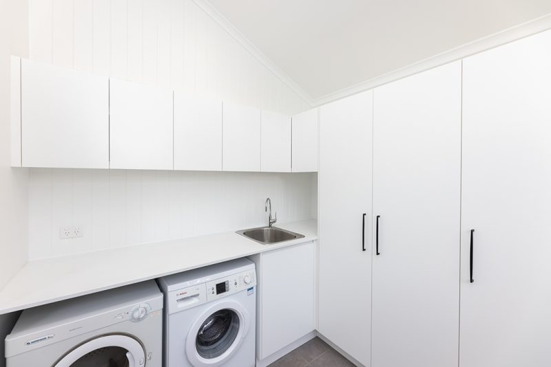 This laundry renovation features plenty of overhead storage