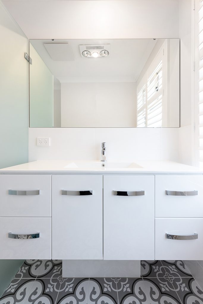 Wide vanity with a large mirror and lots of bathroom storage
