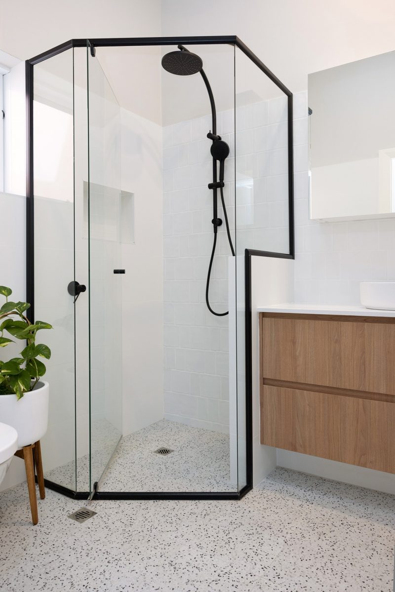 A spacious shower with a black frame renovated by WA Assett Team.