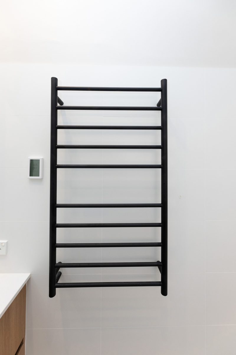 Bathroom renovation, Black towel rail fitted in white wall tile.