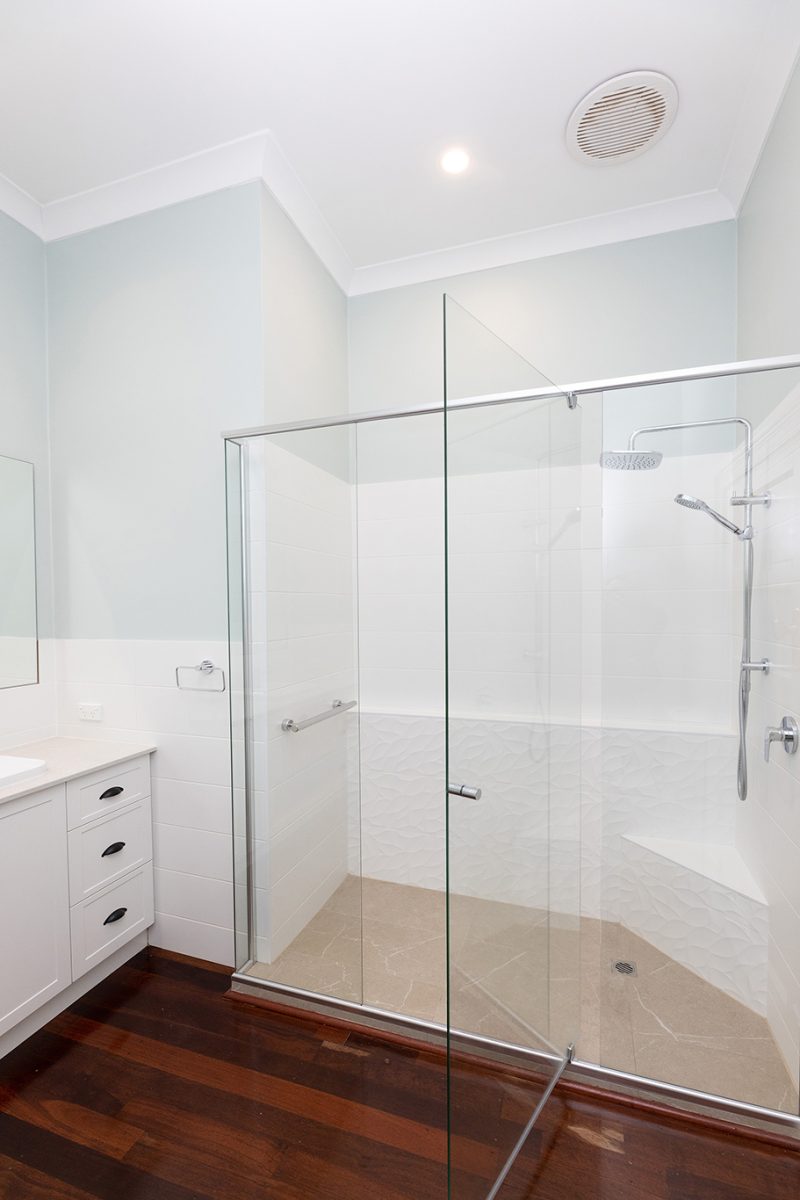 Large shower in bathroom with wooden plank-like flooring