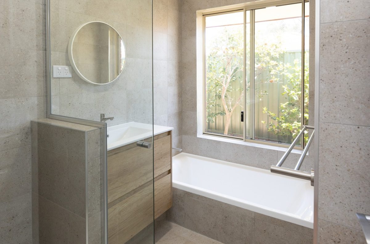 Renovated bathroom with cream coloured tiles, a floating vanity and spacious shower