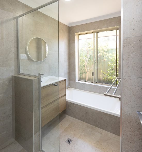 Renovated bathroom with cream coloured tiles, a floating vanity and spacious shower