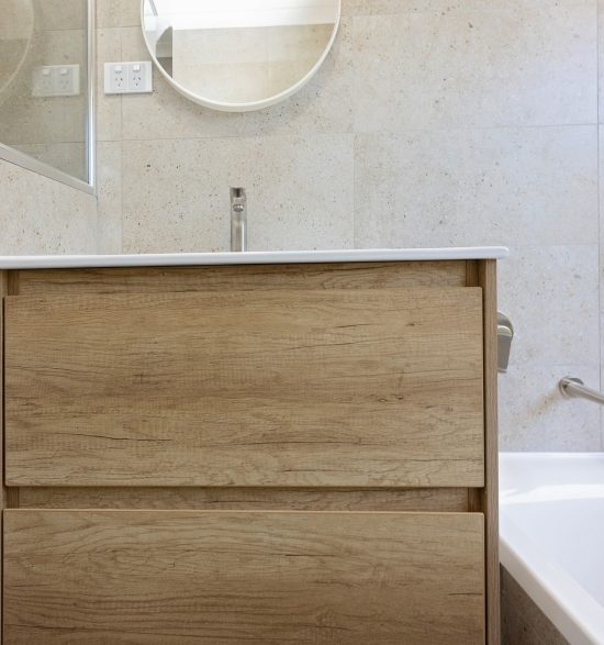 Vanity with wood texture and a small mirror above