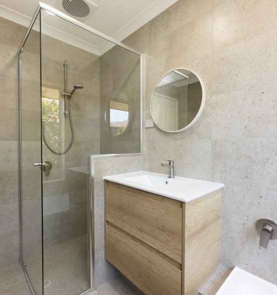 Renovated bathroom with cream coloured tiles, a floating vanity and spacious shower
