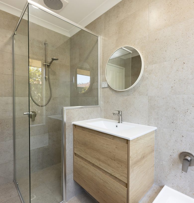 Renovated bathroom with cream coloured tiles, a floating vanity and spacious shower