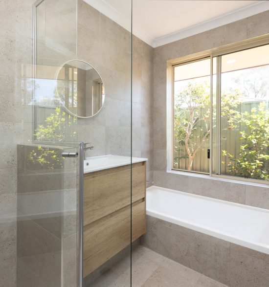 Renovated bathroom with cream coloured tiles, a floating vanity and spacious shower