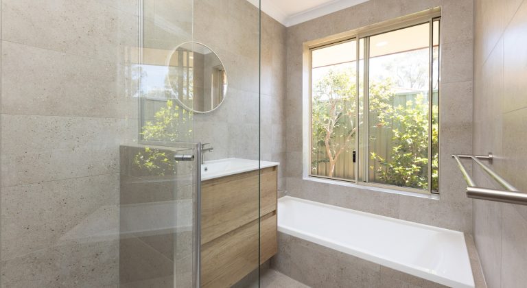 Renovated bathroom with cream coloured tiles, a floating vanity and spacious shower