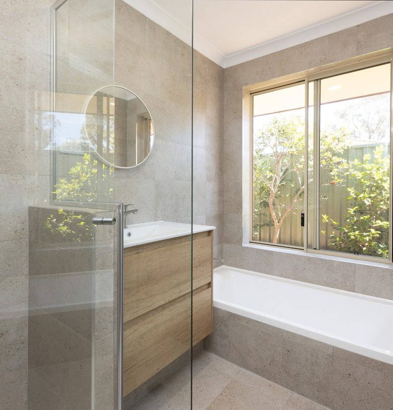 Renovated bathroom with cream coloured tiles, a floating vanity and spacious shower