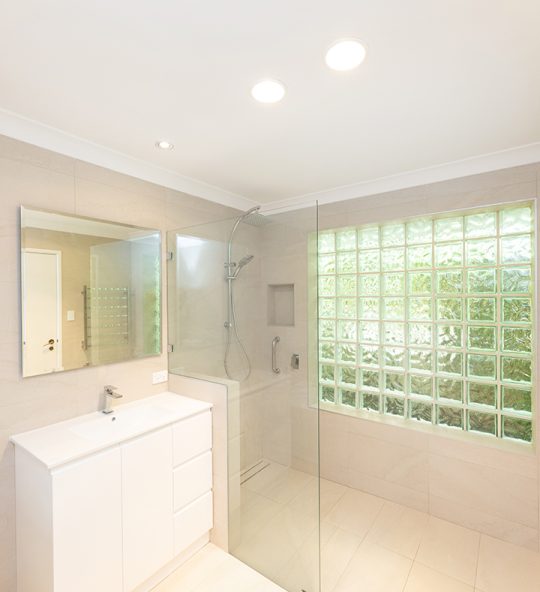Spacious bathroom, with walk in shower and cream coloured tiles