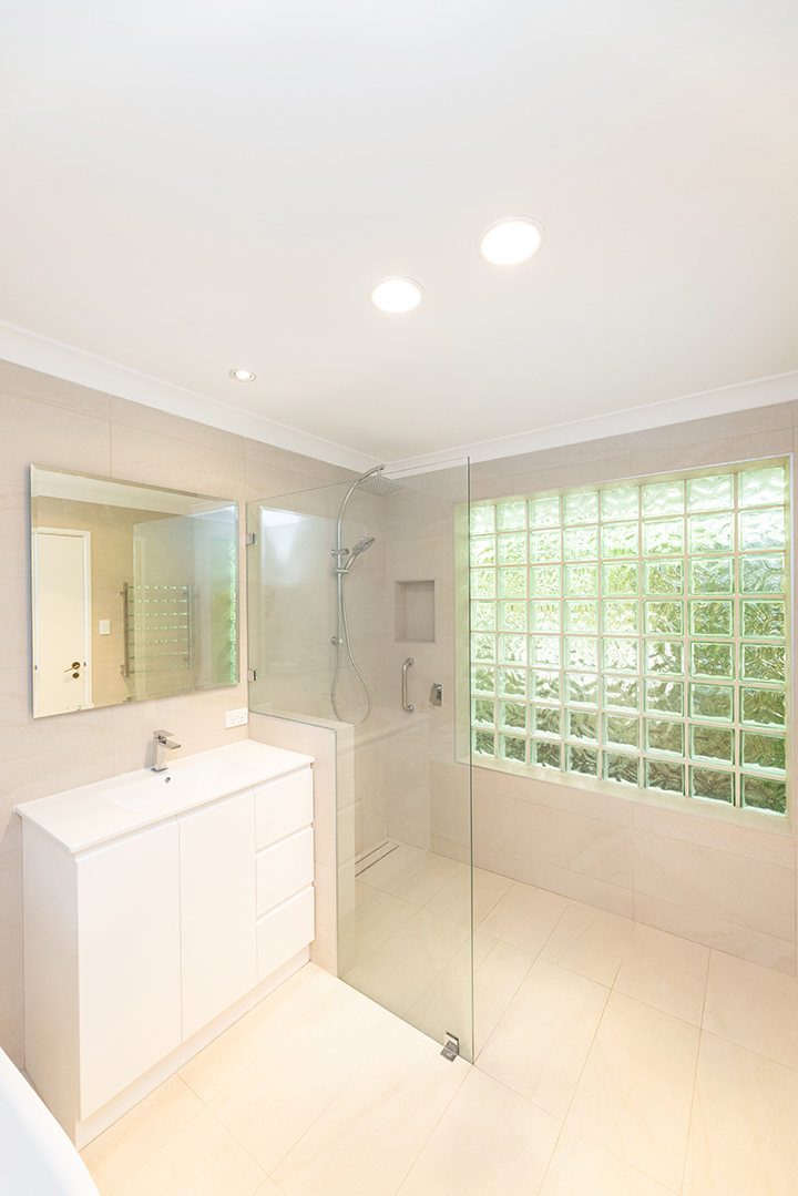Spacious bathroom, with walk in shower and cream coloured tiles