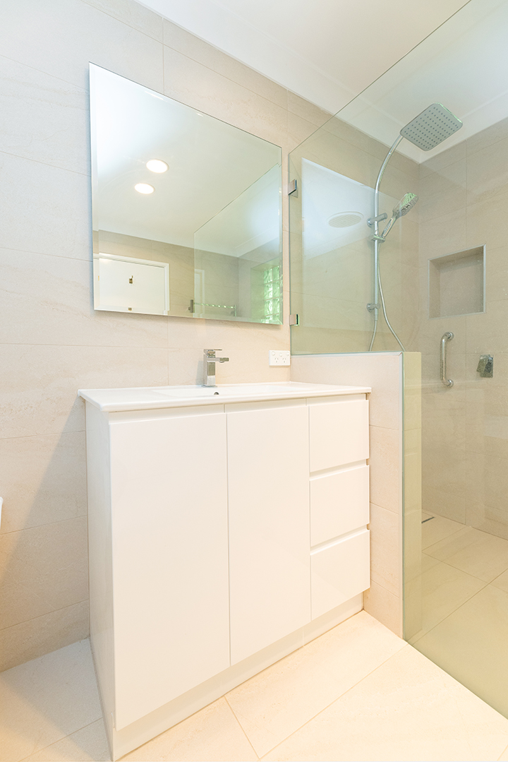 White vanity with square mirror above