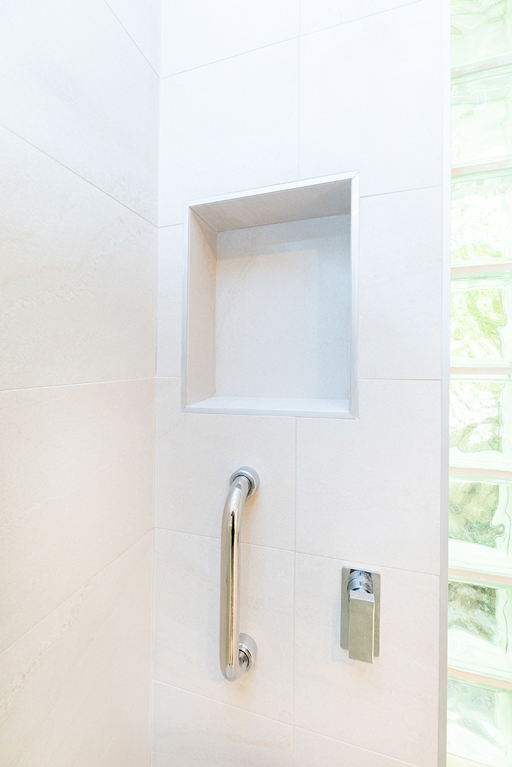 White shower with accessible railing and a lever tap