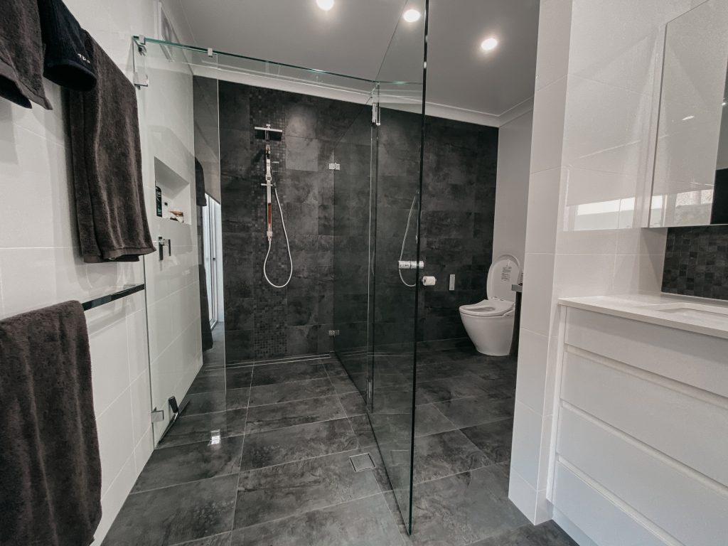A large bathroom with underfloor heating and towel rails, spacious shower