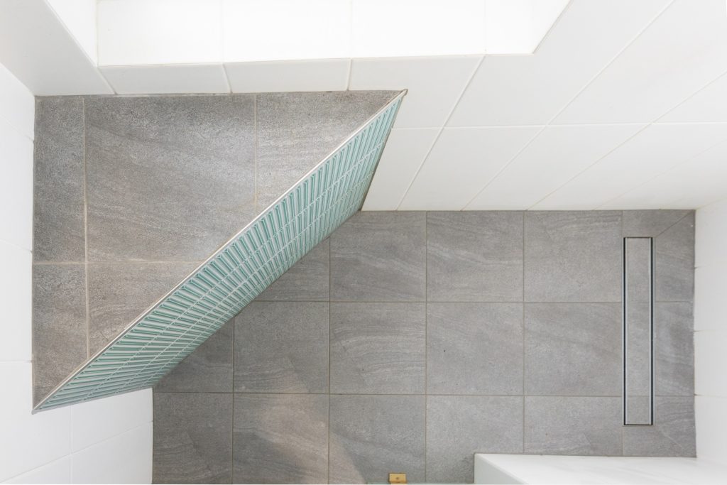 A shower ledge with smooth grey slate