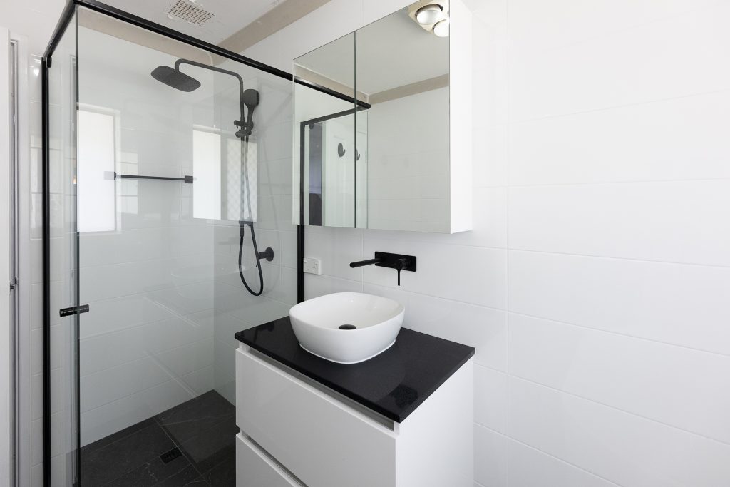 Monochrome bathroom with black and white vanity and spacious shower