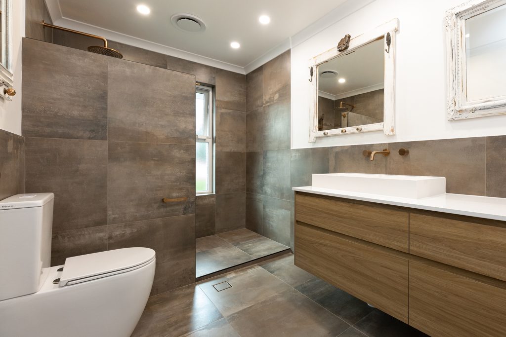 Large bathroom with a spacious shower, wooden tones, and brown slate tiles