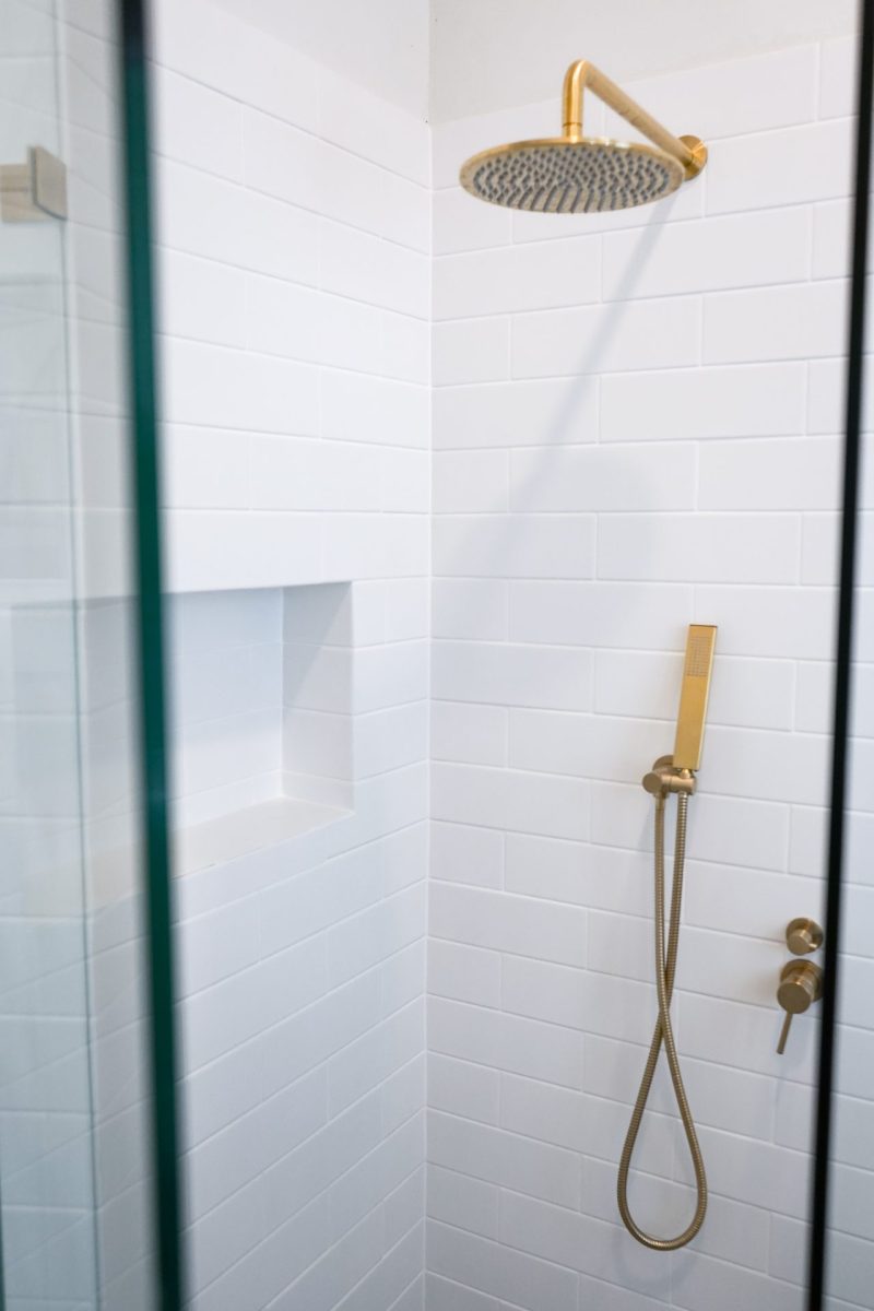 Nedlands CARRATHURS 29 bathroom renovation, golden shower head and white wall tile.